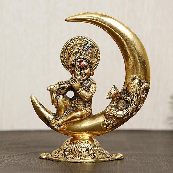 Handcrafted golden metal Lord Krishna idol, depicting him playing the flute on a half moon, showcasing intricate details and elegance.
