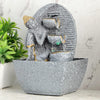 A water fountain featuring a statue of Lord Buddha, the founder of Buddhism, surrounded by cascading waterfalls or a serene pool of water. The fountain may be made of stone, marble, or other materials and may have additional decorative elements, such as plants or lights.