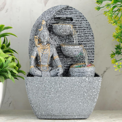 A small, tabletop fountain made of polyresin, a durable and lightweight material. Water flows through the fountain, creating a soothing sound. The fountain may have additional decorative elements, such as rocks, plants, or a figurine.