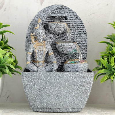 A small, tabletop fountain made of polyresin, a durable and lightweight material. Water flows through the fountain, creating a soothing sound. The fountain may have additional decorative elements, such as rocks, plants, or a figurine.