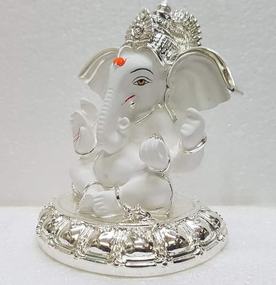 A small golden idol of Ganesha, the Hindu god of wisdom and remover of obstacles, placed on a car dashboard.