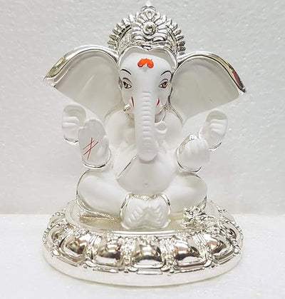 A small golden idol of Ganesha, the Hindu god of wisdom and remover of obstacles, placed on a car dashboard.