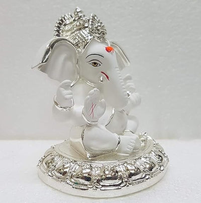 A small golden idol of Ganesha, the Hindu god of wisdom and remover of obstacles, placed on a car dashboard.