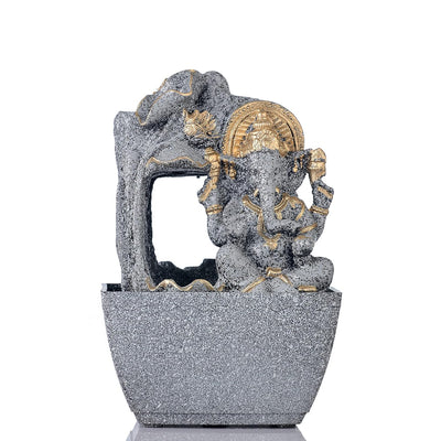A water fountain featuring a statue of Lord Ganesha, the Hindu god of wisdom and remover of obstacles. Water flows around or from the statue, creating a serene and calming atmosphere. The fountain may be made of stone, marble, or other materials and may have additional decorative elements, such as plants or lights