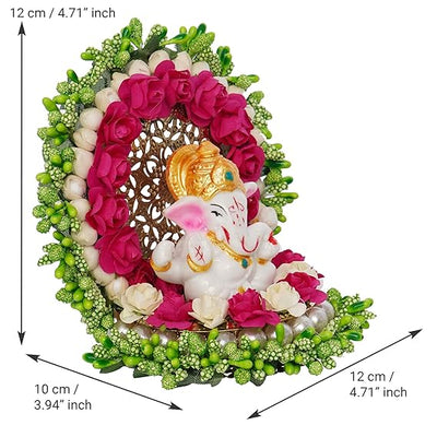 A small golden idol of Lord Ganesha, the Hindu god of wisdom and remover of obstacles, placed on a car dashboard.