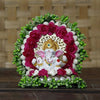 A small golden idol of Lord Ganesha, the Hindu god of wisdom and remover of obstacles, placed on a car dashboard.