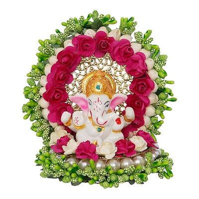 A small golden idol of Lord Ganesha, the Hindu god of wisdom and remover of obstacles, placed on a car dashboard.