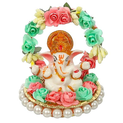  A small golden idol of Lord Ganesha, the Hindu god of wisdom and remover of obstacles, placed on a car dashboard