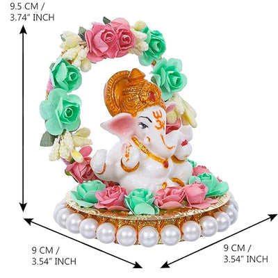  A small golden idol of Lord Ganesha, the Hindu god of wisdom and remover of obstacles, placed on a car dashboard