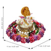  A Hindu god, Lord Ganesha, idol placed on a decorative plate with purple and pink floral designs, suitable for home decor.