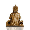 A small golden idol of Lord Hanuman, the Hindu monkey god, seated on a throne made of colorful flowers. The idol is placed on a car dashboard.