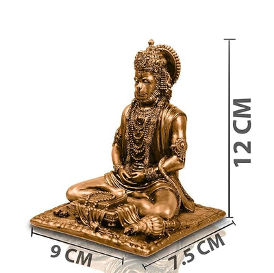 A small golden idol of Lord Hanuman, the Hindu monkey god, seated on a throne made of colorful flowers. The idol is placed on a car dashboard.