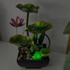A table-top fountain featuring a lotus pond with water gently flowing around and over the lotus flowers.