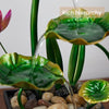 A table-top fountain featuring a lotus pond with water gently flowing around and over the lotus flowers.