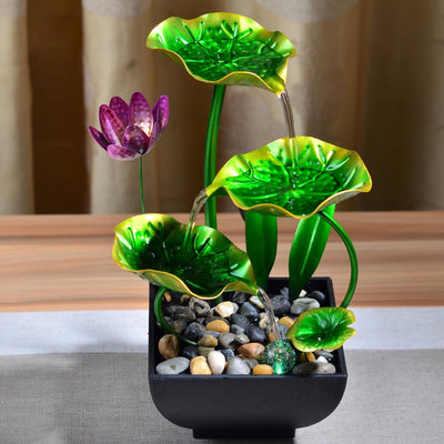 A table-top fountain featuring a lotus pond with water gently flowing around and over the lotus flowers.