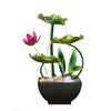 A table-top fountain featuring a lotus pond with water gently flowing around and over the lotus flowers.