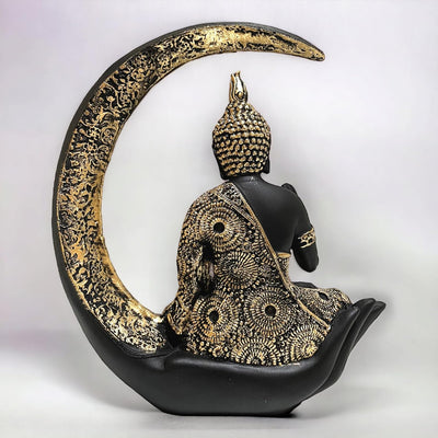 A decorative statue of Buddha seated in meditation pose under a crescent moon. The statue may be made of marble, stone, or another material and may have a serene and calming expression.