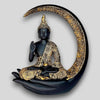 A decorative statue of Buddha seated in meditation pose under a crescent moon. The statue may be made of marble, stone, or another material and may have a serene and calming expression.