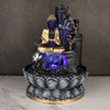 A small, tabletop fountain made of polyresin, a durable and lightweight material. Water flows through the fountain, creating a soothing sound. The fountain may have additional decorative elements, such as rocks, plants, or a figurine.
