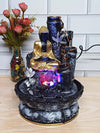 A small, tabletop fountain made of polyresin, a durable and lightweight material. Water flows through the fountain, creating a soothing sound. The fountain may have additional decorative elements, such as rocks, plants, or a figurine.