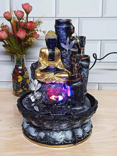 A small, tabletop fountain made of polyresin, a durable and lightweight material. Water flows through the fountain, creating a soothing sound. The fountain may have additional decorative elements, such as rocks, plants, or a figurine.