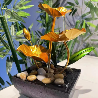 A three-tiered tabletop fountain featuring cascading waterfalls and a decorative base. The fountain may be made of ceramic, stone, or other materials and may have additional decorative elements, such as plants or lights.