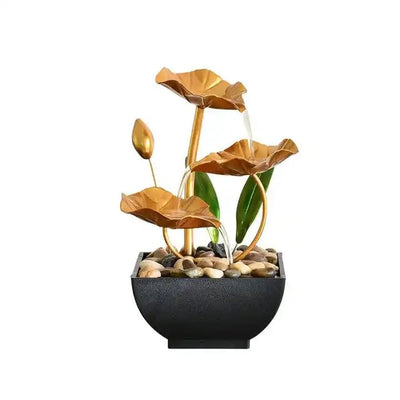 A small, tabletop fountain featuring a lotus flower design. Water flows from the lotus petals or from a nearby source, creating a serene and calming atmosphere. The fountain may be made of ceramic, stone, or other materials and may have additional decorative elements.