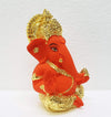Handcrafted ceramic Ganesha idol with gold and sindoor orange finish, symbolizing prosperity and wisdom, ideal for altars and home decor.