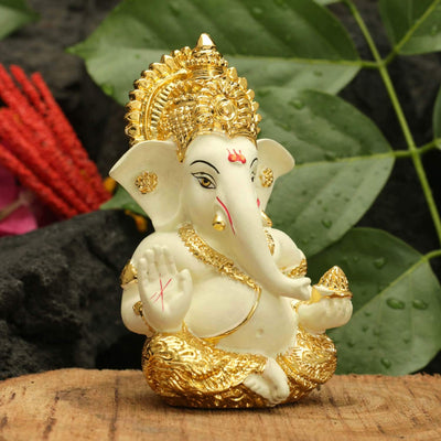Handcrafted gold-plated Ganesha idol made of ceramic, symbolizing protection and good fortune, ideal for car interiors and altars.