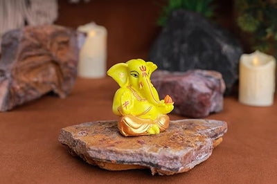 Gold-plated Lord Ganesha idol made of resin, symbolizing prosperity and success. Ideal for home, office, or car decor, showcasing intricate details."