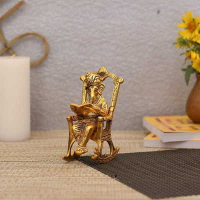 Handcrafted Ganesha Reading Ramayana statue in aluminum, symbolizing wisdom and prosperity, ideal for home decor and spiritual spaces.