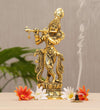 Handcrafted metal Krishna statue playing the flute, featuring intricate details and a gold finish, ideal for home decor or altar.