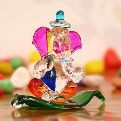 "Handmade Ganesha idol in crystal for car dashboard, featuring intricate details and a radiant finish, perfect for inviting blessings on every journey."