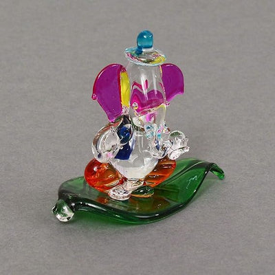 "Handmade Ganesha idol in crystal for car dashboard, featuring intricate details and a radiant finish, perfect for inviting blessings on every journey."