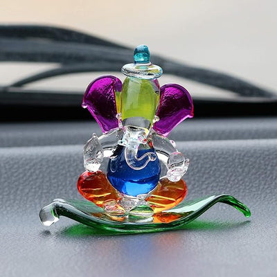 "Handmade Ganesha idol in crystal for car dashboard, featuring intricate details and a radiant finish, perfect for inviting blessings on every journey."