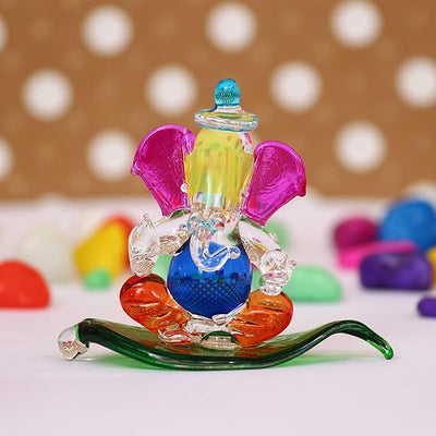"Handmade Ganesha idol in crystal for car dashboard, featuring intricate details and a radiant finish, perfect for inviting blessings on every journey."