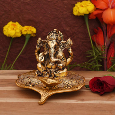 Handmade brass Lord Ganesh diya idol, symbolizing prosperity and wisdom, perfect for home altars, featuring intricate design and vibrant detail.