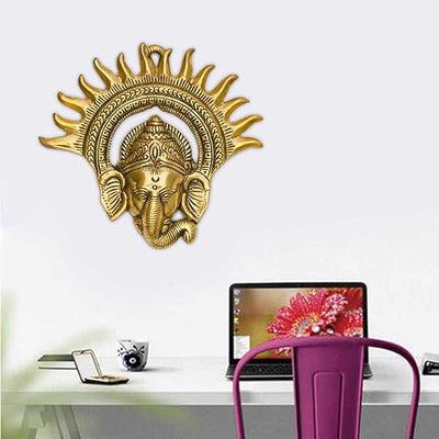 Handmade metal Ganesha wall sculpture with a leaf-shaped design, gold finish, 17.78x17.78 cm, 300g. Ideal for home decor and inviting prosperity and wisdom.