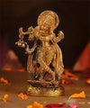 Handcrafted brass statue of Lord Krishna standing on a lotus, featuring a gold finish, representing joy and divine presence.