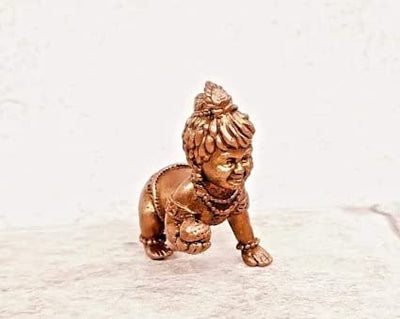 Handmade Lord Baby Krishna idol crafted from copper, featuring intricate detailing. Ideal for home altars and decor, symbolizing faith and spirituality