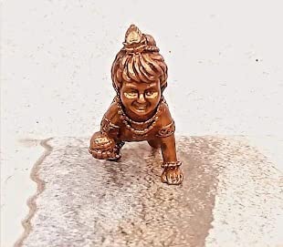 Handmade Lord Baby Krishna idol crafted from copper, featuring intricate detailing. Ideal for home altars and decor, symbolizing faith and spirituality.