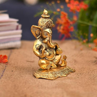 A small golden idol of Lord Ganesha, the Hindu god of wisdom and remover of obstacles, suitable for home decor.