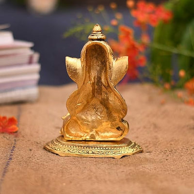 A small golden idol of Lord Ganesha, the Hindu god of wisdom and remover of obstacles, suitable for home decor.