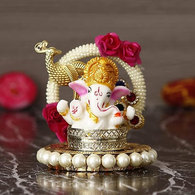A small golden idol of Lord Ganesha, the Hindu god of wisdom and remover of obstacles, suitable for home decor.